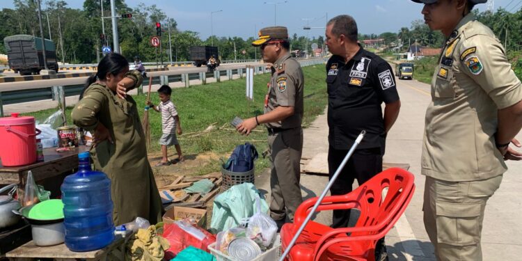 Jadi Tempat Pemberhentian Truk Batubara dan Membahayakan Pengguna Jalan, Lapak Pedagang Kaki Lima di Exit Tol Muaro Sebapo Dibongkar 